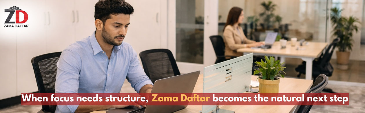 Professional working on a laptop inside a modern coworking space at Zama Daftar, highlighting the transition from home office to structured workspace.