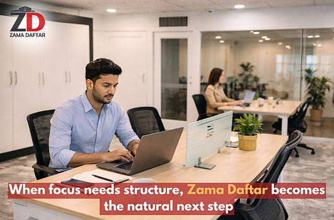 Professional working on a laptop inside a modern coworking space at Zama Daftar, highlighting the transition from home office to structured workspace.